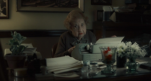 Wide shot frame from Inside Llewyn Davis — sitting, hand, office