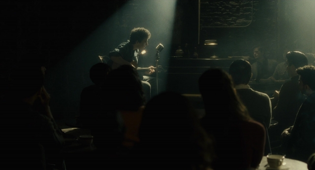 Wide shot frame from Inside Llewyn Davis — sitting, room, person