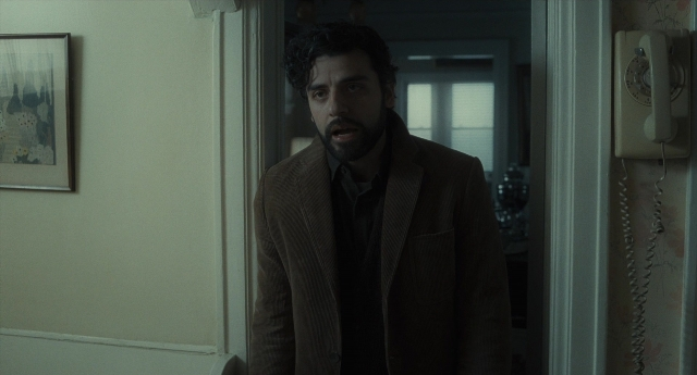 Wide shot frame from Inside Llewyn Davis — standing, phone, coat