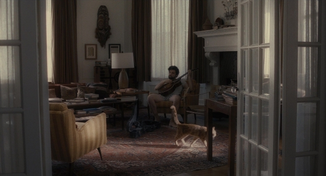 Wide shot frame from Inside Llewyn Davis — sitting, walking, room