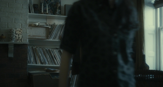 Wide shot frame from Inside Llewyn Davis — book, standing, room
