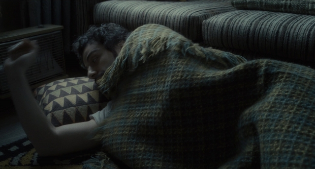 Wide shot frame from Inside Llewyn Davis — room, shirt, couch