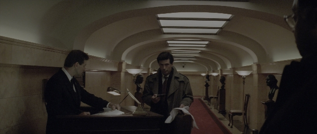 Wide shot frame from The Hunt for Red October — sitting, standing, suit