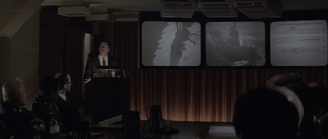 Wide shot frame from The Hunt for Red October — sitting, standing, room