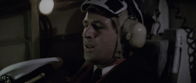Wide shot frame from The Hunt for Red October — sitting, dialogue, hat