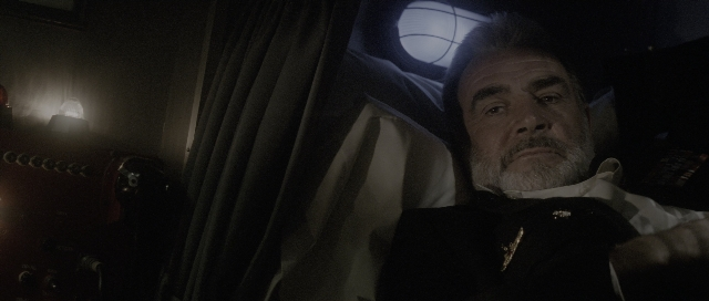 Medium shot frame from The Hunt for Red October — sitting, room, suit