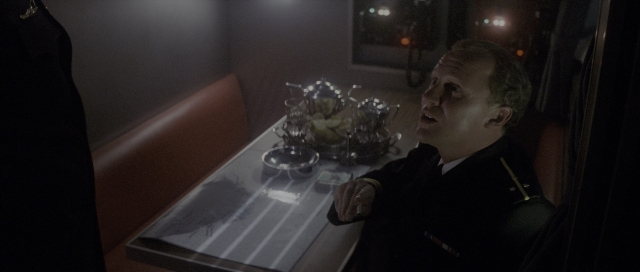 Wide shot frame from The Hunt for Red October — sitting, plate, room