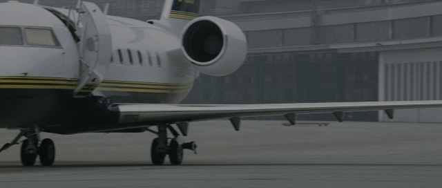 Wide shot frame from The Bourne Supremacy — glass, airplane, wheel
