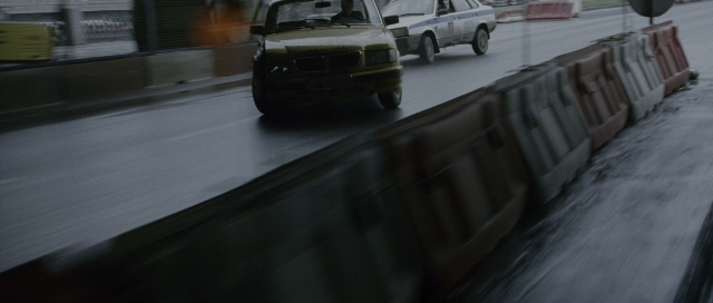 Wide shot frame from The Bourne Supremacy — street, car, wheel