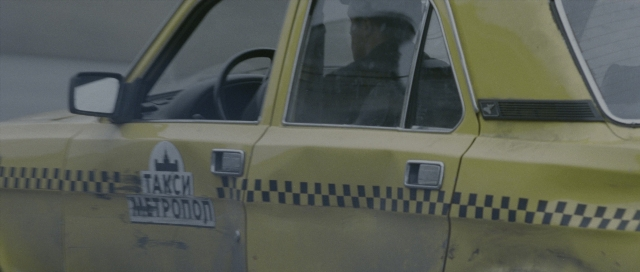 Wide shot frame from The Bourne Supremacy — sitting, plate, car