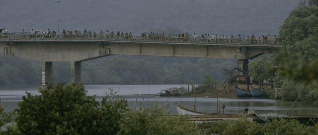 Wide shot frame from The Bourne Supremacy — walking, car, water
