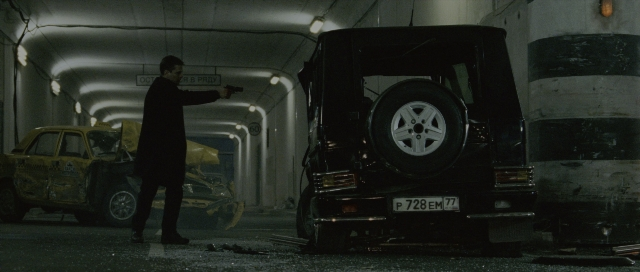 Wide shot frame from The Bourne Supremacy — standing, plate, car