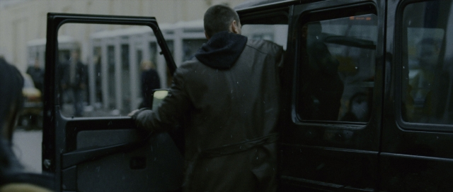 Wide shot frame from The Bourne Supremacy — standing, door, street