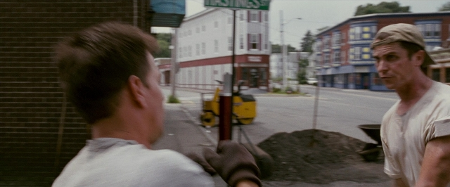Wide shot frame from The Fighter — standing, street, hat