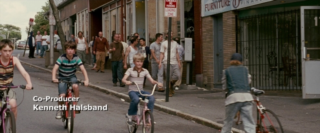 Wide shot frame from The Fighter — walking, street, bicycle