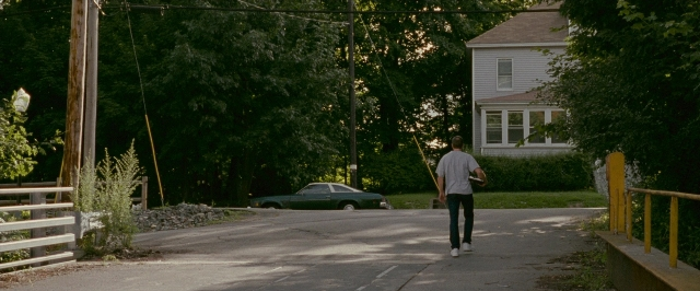 Wide shot frame from The Fighter — walking, street, car