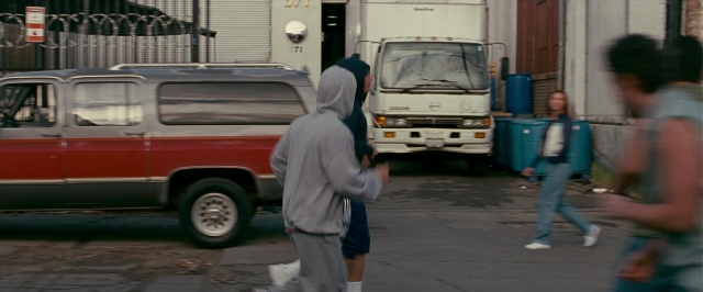 Wide shot frame from The Fighter — walking, street, van