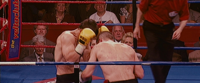 Wide shot frame from The Fighter — standing, shirt, fight