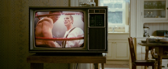 Wide shot frame from The Fighter — table, kitchen, television