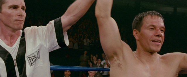 Medium shot frame from The Fighter — standing, shirt, face