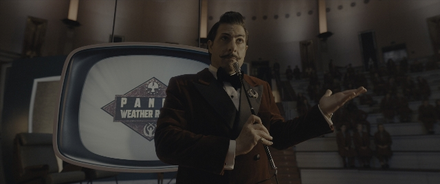 Wide shot frame from The Hunger Games: The Ballad of Songbirds & Snakes — standing, dialogue, hand