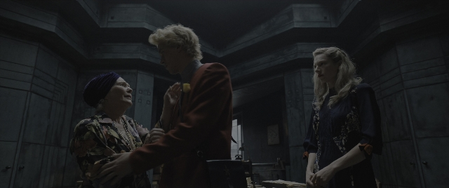 Medium shot frame from The Hunger Games: The Ballad of Songbirds & Snakes — standing, room, dialogue