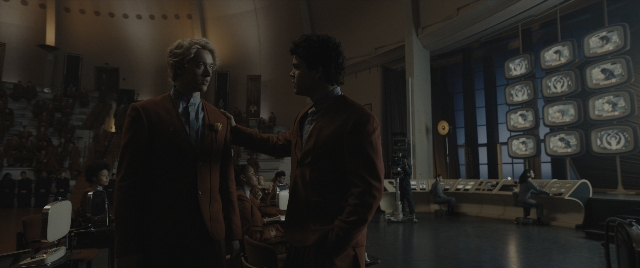 Wide shot frame from The Hunger Games: The Ballad of Songbirds & Snakes — sitting, standing, room