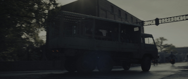 Wide shot frame from The Hunger Games: The Ballad of Songbirds & Snakes — street, car, truck