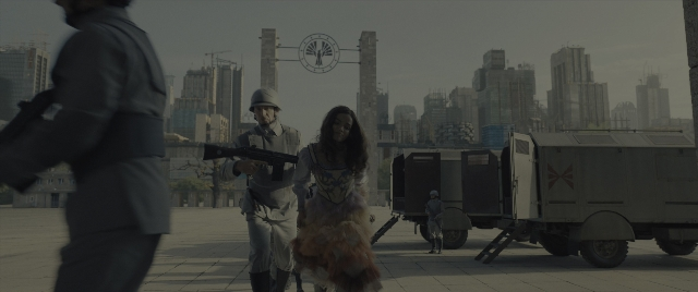 Wide shot frame from The Hunger Games: The Ballad of Songbirds & Snakes — walking, hat, dog
