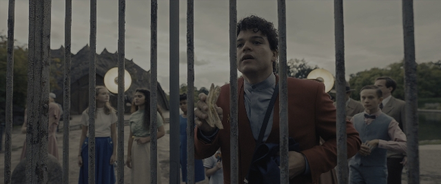 Wide shot frame from The Hunger Games: The Ballad of Songbirds & Snakes — standing, suit, hair