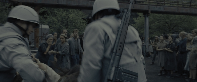 Wide shot frame from The Hunger Games: The Ballad of Songbirds & Snakes — standing, person, human face