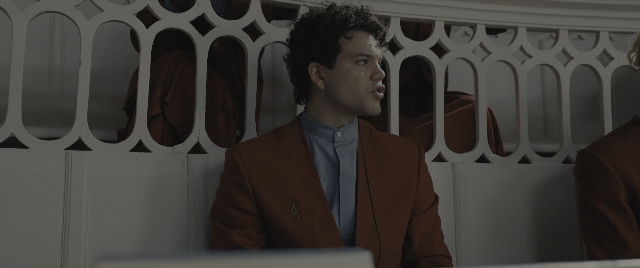Wide shot frame from The Hunger Games: The Ballad of Songbirds & Snakes — standing, suit, shirt