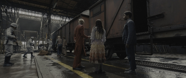 Wide shot frame from The Hunger Games: The Ballad of Songbirds & Snakes — standing, car, train