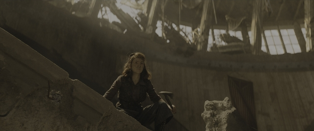 Wide shot frame from The Hunger Games: The Ballad of Songbirds & Snakes — sitting, shirt, face