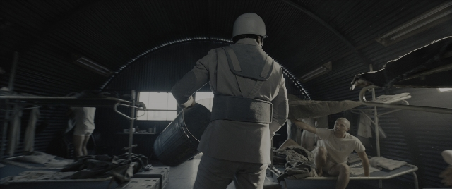 Wide shot frame from The Hunger Games: The Ballad of Songbirds & Snakes — walking, room, hat