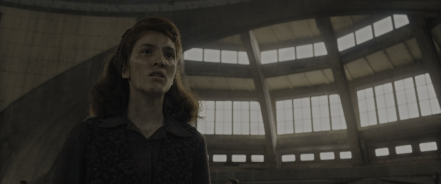 Wide shot frame from The Hunger Games: The Ballad of Songbirds & Snakes — standing, room, shirt