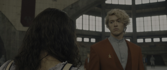 Medium shot frame from The Hunger Games: The Ballad of Songbirds & Snakes — standing, room, suit