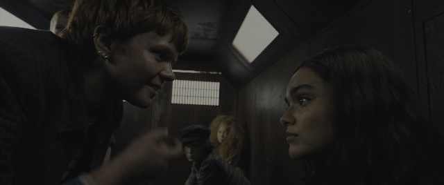 Wide shot frame from The Hunger Games: The Ballad of Songbirds & Snakes — standing, room, hand
