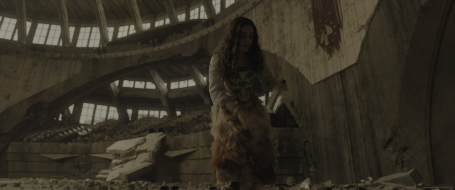 Wide shot frame from The Hunger Games: The Ballad of Songbirds & Snakes — standing, dress, face