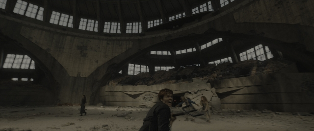 Wide shot frame from The Hunger Games: The Ballad of Songbirds & Snakes — standing, walking, gun
