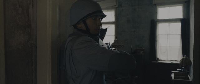 Wide shot frame from The Hunger Games: The Ballad of Songbirds & Snakes — standing, room, hat