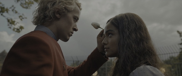 Medium shot frame from The Hunger Games: The Ballad of Songbirds & Snakes — standing, hand, face