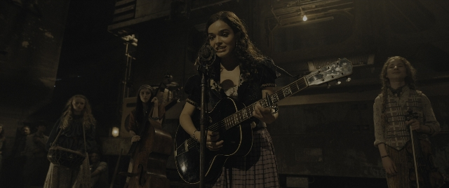Wide shot frame from The Hunger Games: The Ballad of Songbirds & Snakes — standing, dress, hair