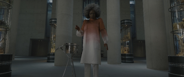 Wide shot frame from The Hunger Games: The Ballad of Songbirds & Snakes — standing, room, hand