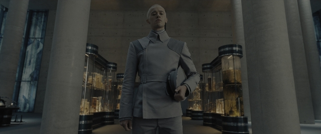 Wide shot frame from The Hunger Games: The Ballad of Songbirds & Snakes — standing, room, coat