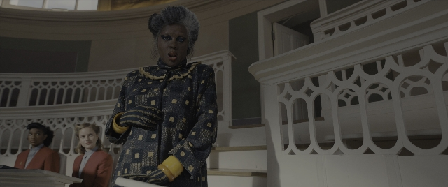 Wide shot frame from The Hunger Games: The Ballad of Songbirds & Snakes — standing, room, coat