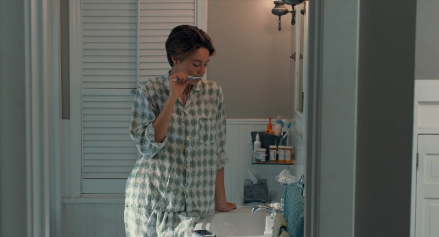 Wide shot frame from The Fault in Our Stars — standing, mirror, hand