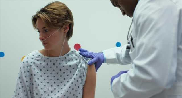 Wide shot frame from The Fault in Our Stars — bed, coat, face