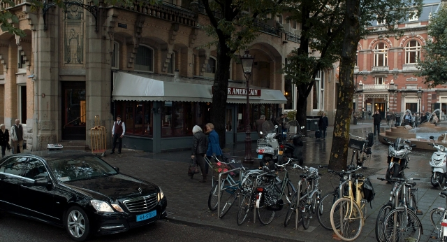 Wide shot frame from The Fault in Our Stars — sitting, walking, street