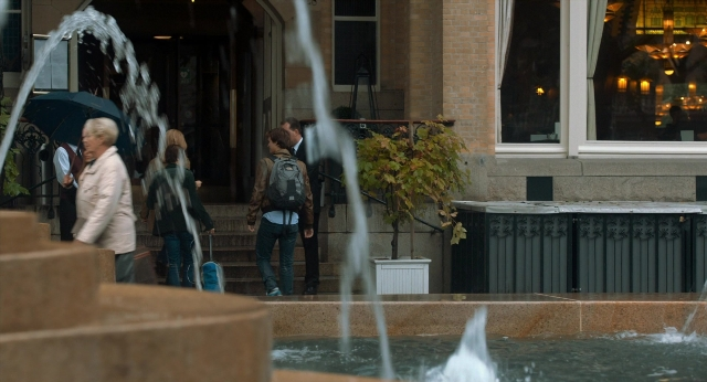 Wide shot frame from The Fault in Our Stars — walking, water, umbrella